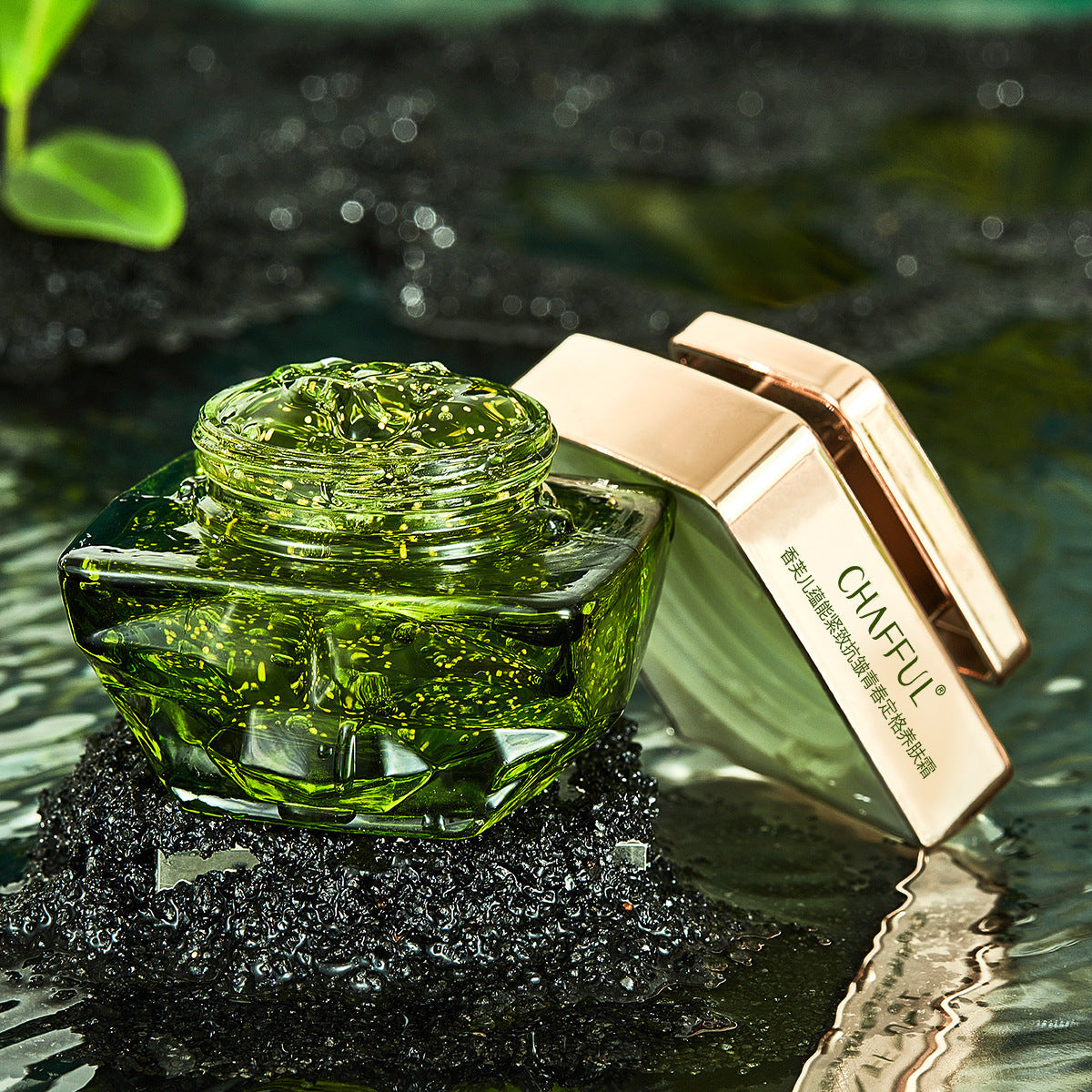 Green cosmetic jar with rose gold lid on a reflective surface with blurred green leaves in the background
