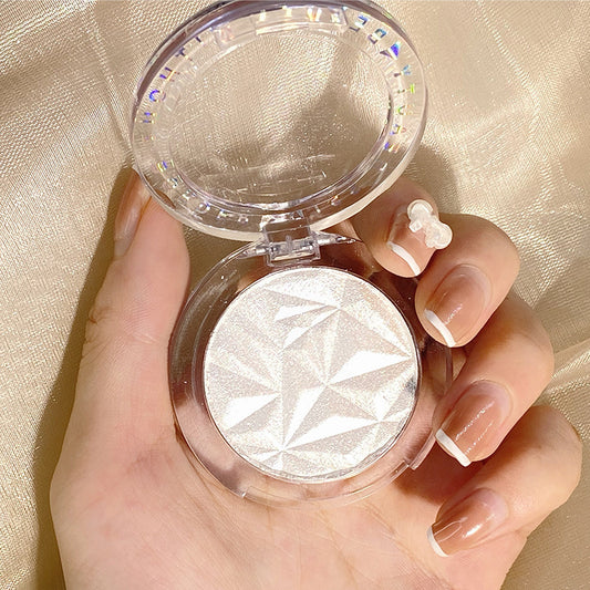 Hand holding a compact mirror with a decorative case on a gold background
