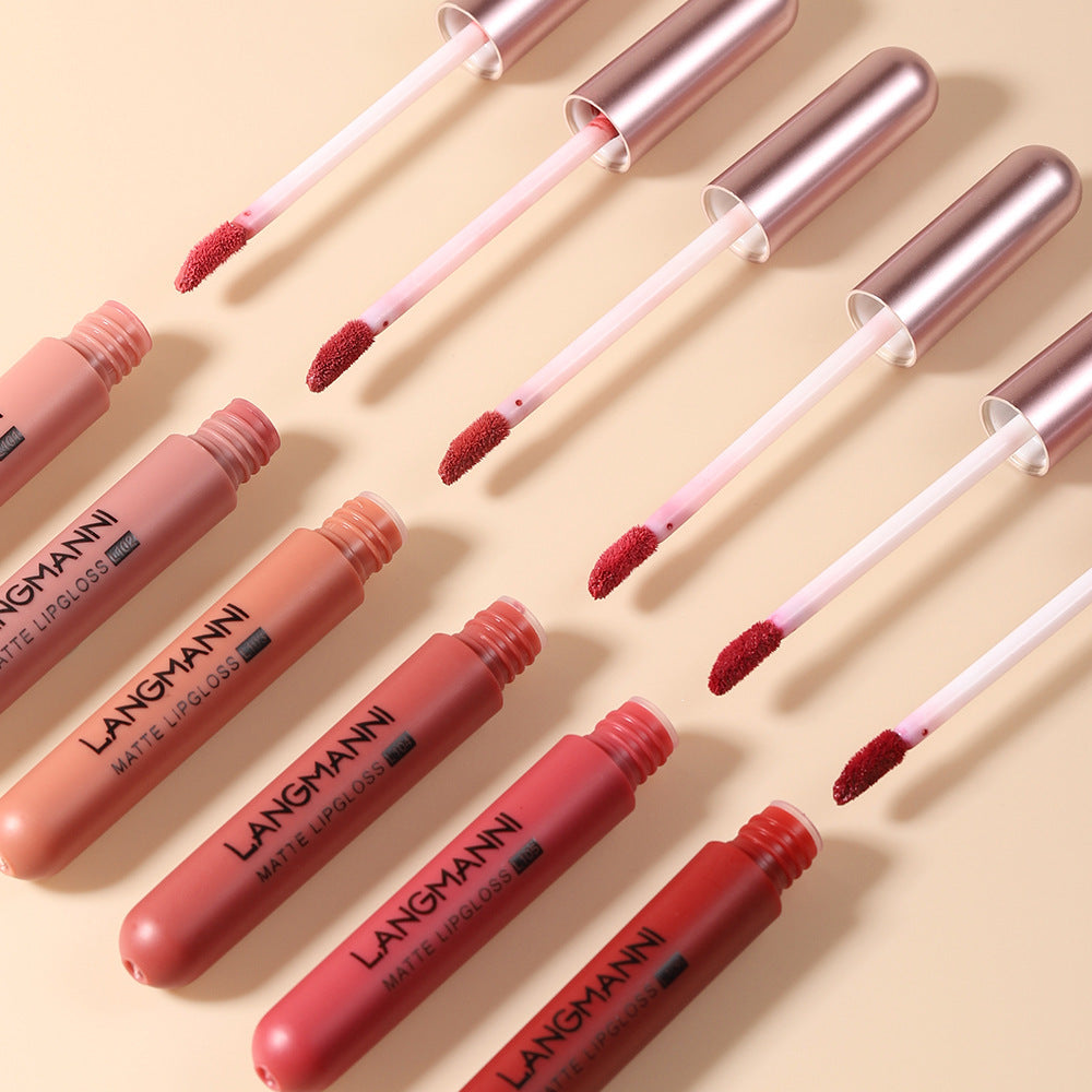 Set of Langmann matte lip glosses with applicators on a beige background
