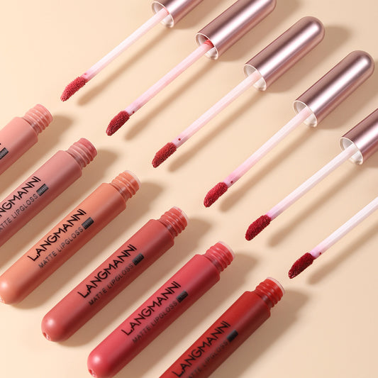 Set of Langmann matte lip glosses with applicators on a beige background